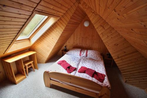 a bedroom with a bed in a wooden attic at Apartmány Jakub in Belá