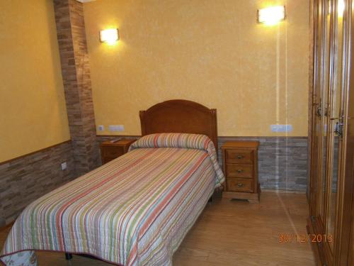 a small bedroom with a bed and a night stand at Legaire Etxea in Ibarguren