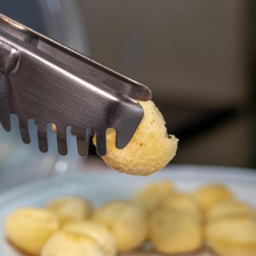 a person holding a piece of food in a knife at Pousada Bellissima Italia in Luis Correia