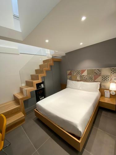 a bedroom with a bed and a staircase at Hotel Medinblu in Reggio Calabria