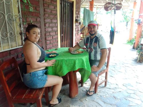 a man and a woman sitting at a table at Beach cabin ometepe in Altagracia