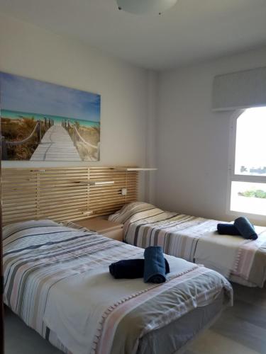 2 Betten in einem Zimmer mit Wandgemälde in der Unterkunft Balcones del Chaparral in Mijas , Costa des sol . in Mijas Costa