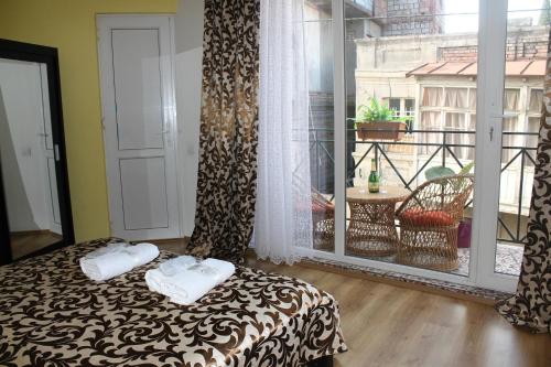 1 dormitorio con cama y ventana grande en Qeroli old town, en Tiflis