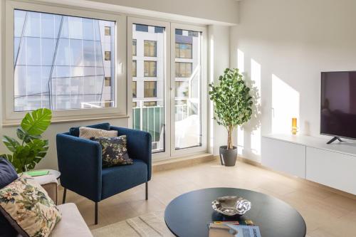 uma sala de estar com uma cadeira azul e uma mesa em Hamilius Apartments City Center Luxembourg by Rentaroo em Luxemburgo