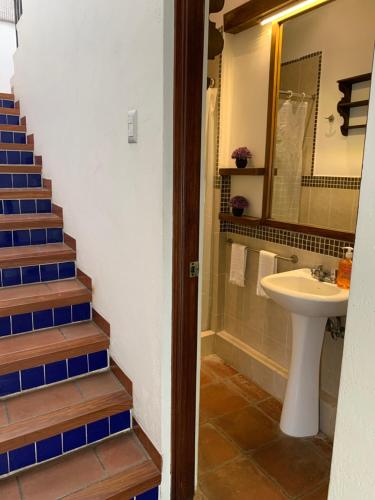 a bathroom with a sink and a toilet and stairs at Casa Anabel in Antigua Guatemala