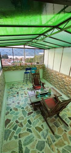a room with a table and chairs on a stone floor at HOSPEDAJE DE GUATAVITA in Guatavita