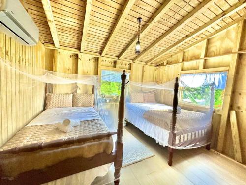 um quarto com 2 camas num chalé de madeira em Cabaña Recordando El Ayer em San Lorenzo