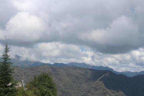 a view of a mountain under a cloudy sky at Veda Inn in Chakrāta