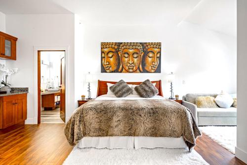 a bedroom with a large bed with a painting of masks at LUXE Penthouse with Mountain Views Solar A Resort & Spa in Canmore