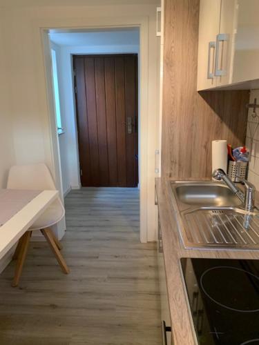 a kitchen with a sink and a hallway with a door at Stadtteil-Apartment in Fulda