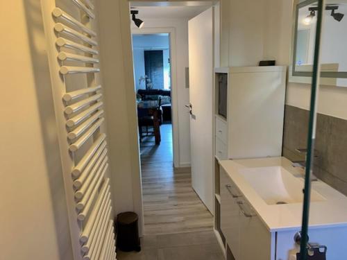 a kitchen with white cabinets and a dining room at Stadtteil-Apartment in Fulda