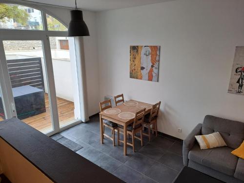 uma sala de estar com uma mesa e um sofá em Bel Appartement Grande Terrasse avec parking à Dijon em Dijon