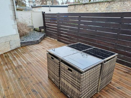 un patio avec une terrasse en bois et une clôture en bois dans l'établissement Bel Appartement Grande Terrasse avec parking à Dijon, à Dijon