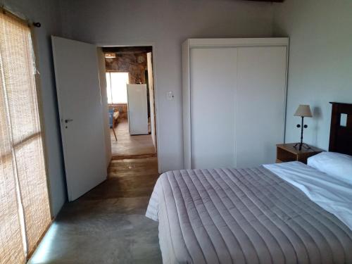 1 dormitorio con 1 cama y puerta que da a un pasillo en Los chañares en San Javier