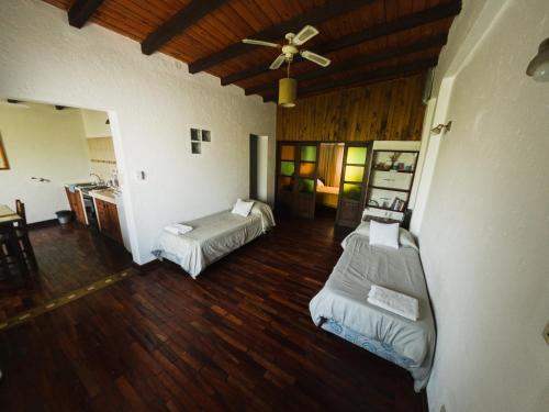 een woonkamer met 2 bedden en een plafondventilator bij La Casita de Salta in Salta