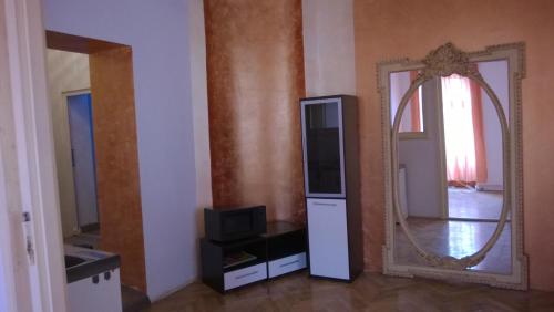 um quarto com um espelho e uma televisão e um suporte de televisão em M Central Apartments em Cluj-Napoca