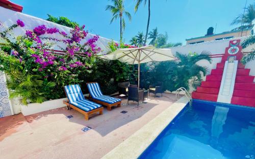 two chairs and an umbrella next to a swimming pool at Casa Piramide: Fully Furnished 2-Bedroom House w/ Private Swimming Pool and Waterfall, 5 Minute Walk from the Beach in Barra de Navidad