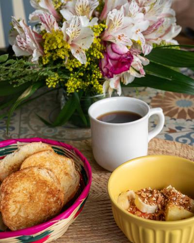 a table with a cup of coffee and a bowl of bread at Hotel Ocho Barrios in San Cristóbal de Las Casas
