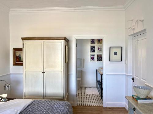 a bedroom with a white cabinet and a desk at 1 Royal Street Guesthouse in Riebeek-Kasteel