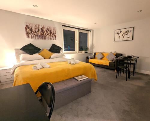 een slaapkamer met een geel bed en een bank bij Studio for Professionals Trades Relocators in Cardiff
