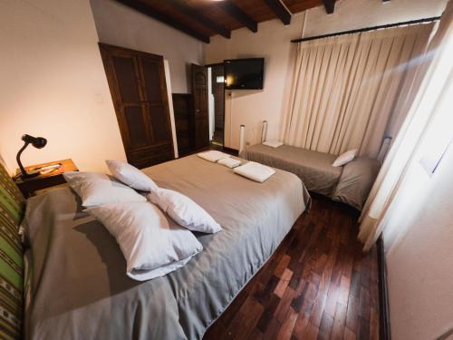 una camera d'albergo con due letti con cuscini di La Casita de Salta a Salta
