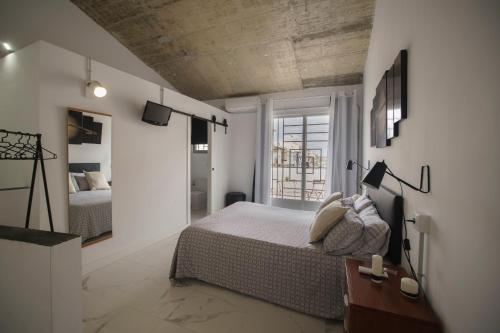 1 dormitorio con cama y ventana grande en Casa suig, en Baena