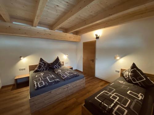 a bedroom with two beds and a wooden ceiling at Alpenliebe Pitztal in Sankt Leonhard im Pitztal