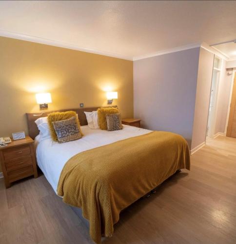 a bedroom with a large bed with two pillows at The Manor Hotel in Crickhowell