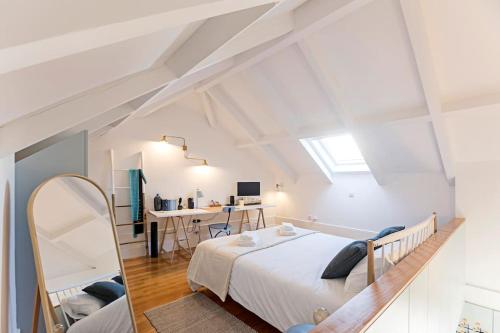 een witte slaapkamer met een bed en een bureau bij O Aleph, irresistible duplex apt. w/AC and balcony in Porto