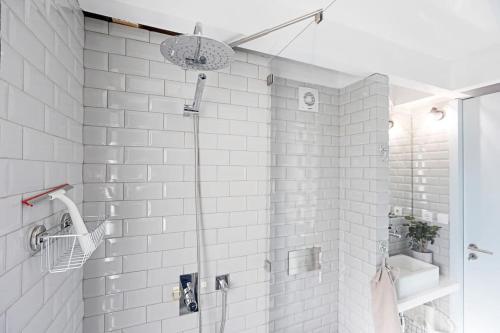 een badkamer met een douche en een witte tegelwand bij O Aleph, irresistible duplex apt. w/AC and balcony in Porto