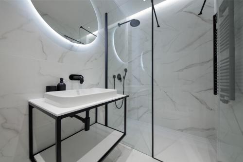 ザグレブにあるLuxury Haven in Zagrebの洗面台とシャワー付きの白いバスルーム