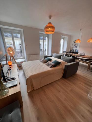 ein großes Schlafzimmer mit einem Bett und einem Sofa in der Unterkunft Bel appartement T3 rénové avec cour intérieure - Villa Marie in Luchon