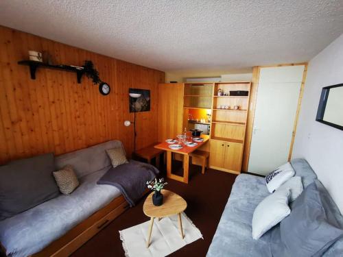 un salon avec un canapé et une table dans l'établissement Appartement ski au pied 5-6 personnes La plagne tarentaise, à Plagne Villages