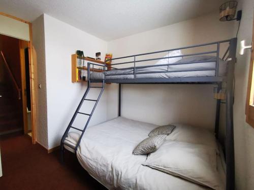 une chambre avec deux lits superposés et une échelle dans l'établissement Appartement ski au pied 5-6 personnes La plagne tarentaise, à Plagne Villages