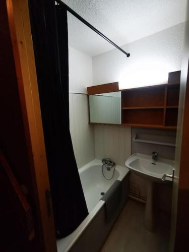 une petite salle de bain avec une baignoire et un lavabo dans l'établissement Appartement ski au pied 5-6 personnes La plagne tarentaise, à Plagne Villages