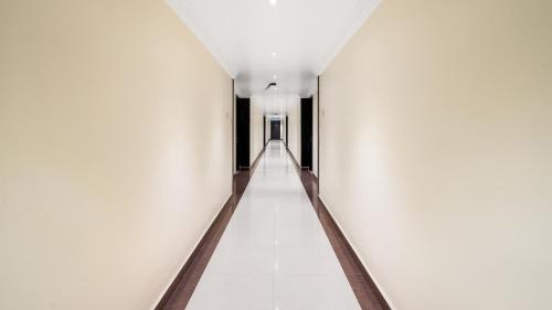 a corridor of a building with white walls at Niranjana Hotel Bodhgaya in Bodh Gaya