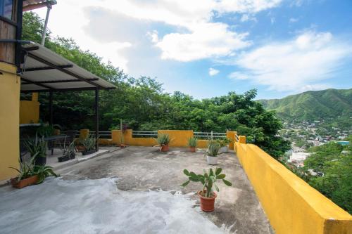 a balcony of a house with a yellow fence and plants at Perth House Taganga in Taganga