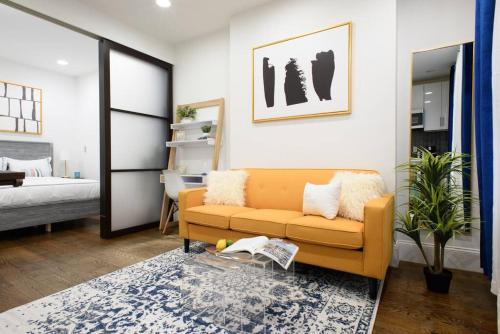 een woonkamer met een bank en een bed bij 69-2A PRIME Lower East Side 1br Apt Brand New in New York