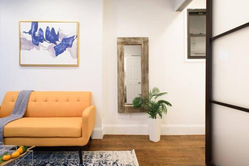 a living room with a couch and a mirror at 69-2B Prime Lower East East BRAND NEW 1br Apt in New York