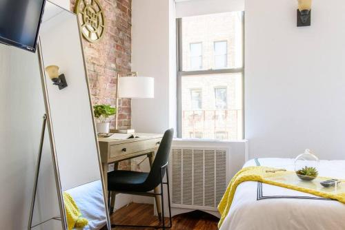 - une chambre avec un bureau et une chaise devant une fenêtre dans l'établissement 24-16 Studio Gramercy W D gramercy, à New York