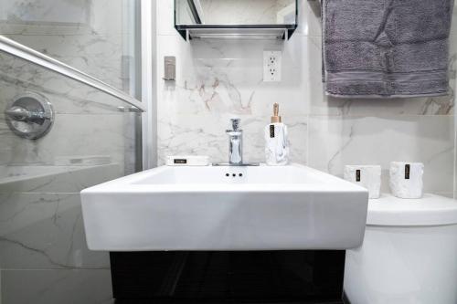 Baño blanco con lavabo y aseo en 69-3C Stylish Lower East East 1br Apt BRAND NEW, en Nueva York