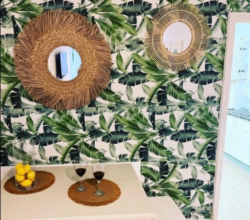two mirrors on a wall with a tropical wallpaper at Stadiumapartament in Santa Cruz de Tenerife