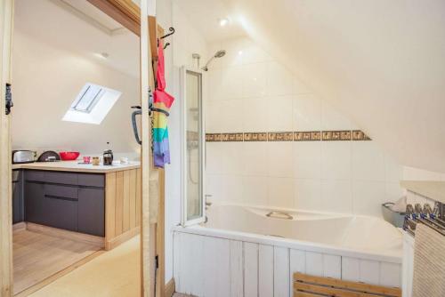 a bathroom with a large tub and a sink at Rainbow Barns in Bourton on the Water