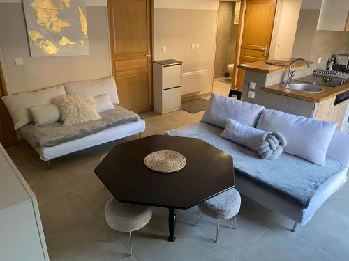 uma sala de estar com um sofá e uma mesa em CLICHY SOUS BOIS APPARTEMENT RÉCENT & CHALEUREUX em Clichy-sous-Bois