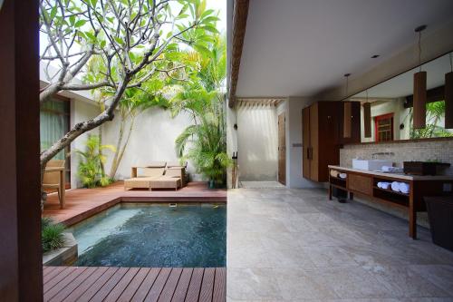 a villa with a swimming pool and a living room at The Amala Boutique Retreat in Seminyak