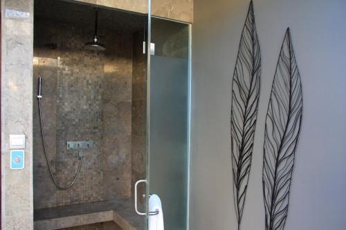 a shower with a glass door in a bathroom at The Amala Boutique Retreat in Seminyak