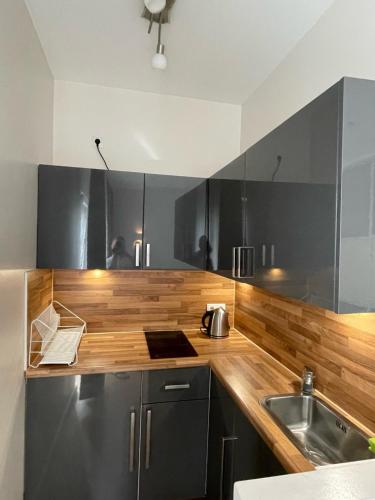 una cucina con ripiani in legno e lavandino di Secret Studio Lux SPECIAL OFFER a Berlino