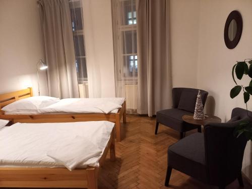 a hotel room with two beds and a chair at Teytz Apartments in Prague