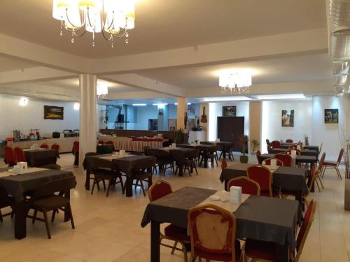 un ristorante con tavoli e sedie e una sala da pranzo di Hotel Sinaia Palace a Erbil