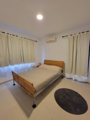 a bedroom with a bed and curtains and a rug at Modern - Wan Pipel with Terrace in Paramaribo